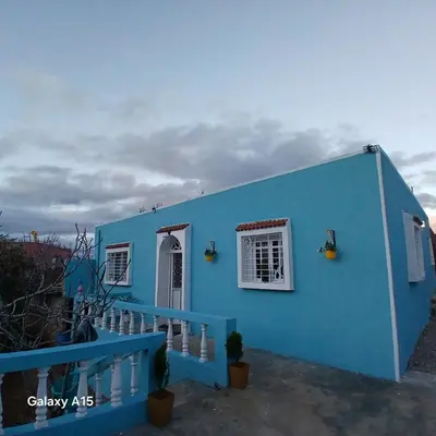 a blue house with a white window and a staircase at Maison d'Azur in Imouzzer Kandar