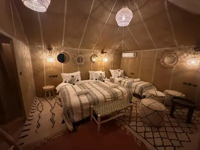a room with four beds in a tent at ChariF Luxury Camp in Rissani