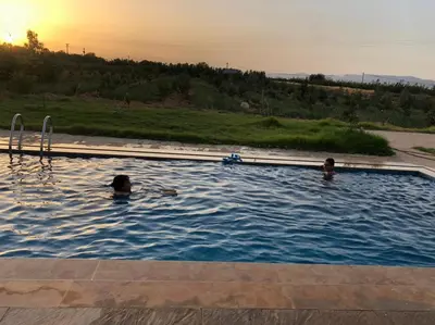 two people are swimming in a swimming pool at Villa Adam in Meknès