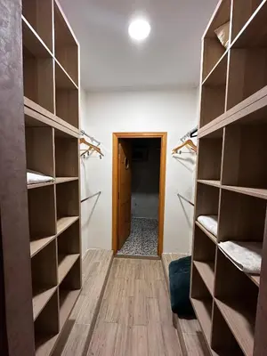 a walk in closet with wooden shelves and a hallway at Villa Adam in Meknès