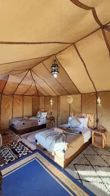 a bedroom with two beds in a tent at Starry Luxury Camp in Merzouga