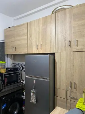 a kitchen with a refrigerator and wooden cabinets at Dar Tranquila in Fès