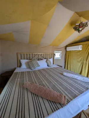 a bedroom with a large bed in a tent at Luxury Desert Camp with AC & Heating in Merzouga in Lac Yasmins
