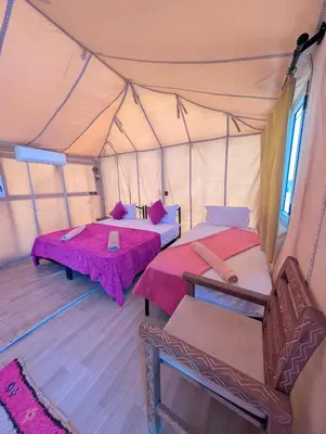 a room with two beds in a tent at Air Conditioning Berber Desert Camp in Merzouga