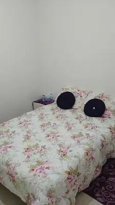 a bed with a floral bedspread with two pillows on it at Reda Ghazalie in Meknès