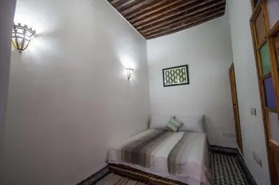 a bedroom with a bed in the corner of a room at Dar Miouda Fes in Fès