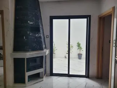 a living room with a glass door and a fireplace at Bella Nova Air-Conditioned Apartment in Azrou
