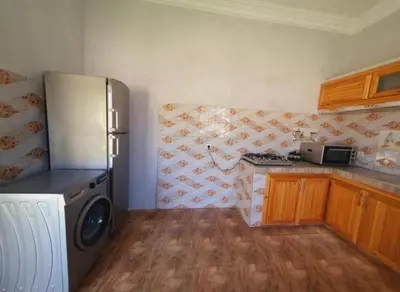 a kitchen with a refrigerator and a stove at Maison Royale in Douar bel Rhanodour