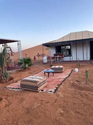 a building in the middle of the desert with a table at Luxury Desertcamp in Merdani