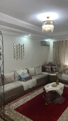a living room with a couch and a table at Appartement moderne et entièrement meublé in Khemisset
