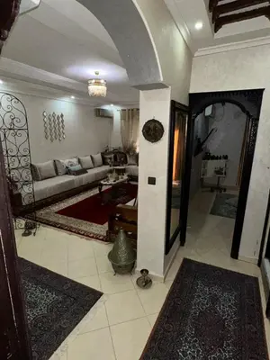 a living room with a couch and a table at Appartement moderne et entièrement meublé in Khemisset
