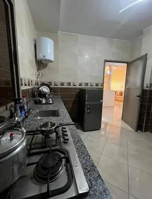 a kitchen with a stove top and a sink at Sahara Luxury Apartments in Hassilabied