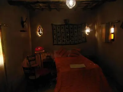 a bedroom with a bed with a red blanket at Dar dmana chez l'habitant in Skoura
