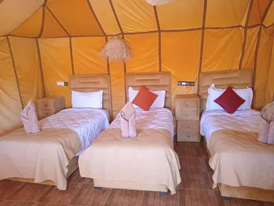 a group of three beds in a tent at Good vibes desert camp in Merzouga