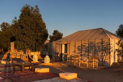 a tent with tables and chairs in front of it at moroccan izem camp in Merzouga