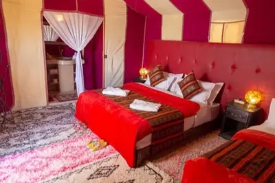 a bedroom with a bed with a red head board at Merzouga Dream Starlight in Merzouga