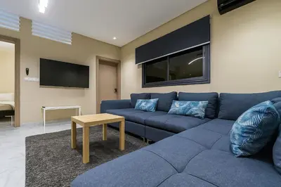 a living room with a blue couch and a tv at Relax Family 12 - Cozy Entire Apartment in City Center in Ouarzazate