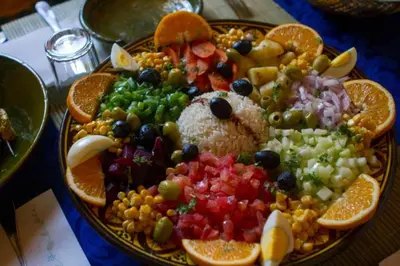 a plate of food with fruit and vegetables on a table at Merzouga Dune Camp in Merzouga