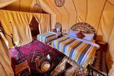 a bedroom with two beds in a tent at Merzouga Twilight Camp in Merzouga