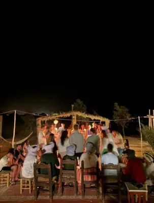 a group of people sitting in chairs at night at Luxury tent nomads in Merzouga