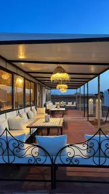 a patio with tables and chairs and a chandelier at Starvile Luxury Camp in Merzouga