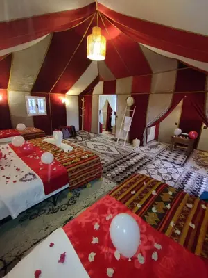 a large room with two beds and a chandelier at Starvile Luxury Camp in Merzouga