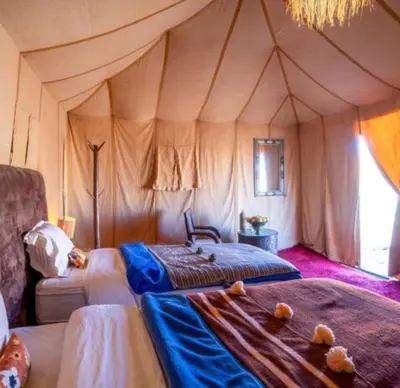 a bedroom with a tent with a bed in it at Morocco luxury Camp in Merzouga