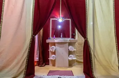 a bathroom with a sink in a room with curtains at Morocco luxury Camp in Merzouga