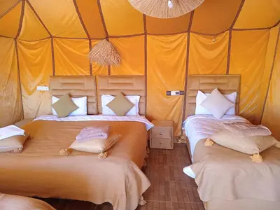 a bedroom with two beds in a tent at Dune's treasure, luxury camp in Merzouga