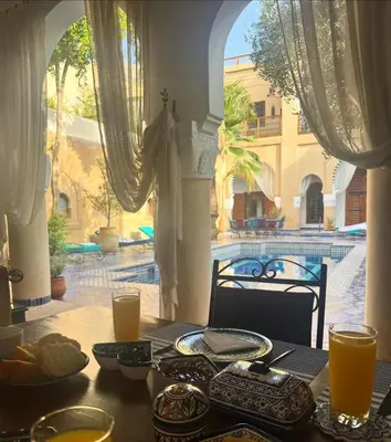 a table with food on it with a view of a building at Chambre topaze - Riad lotus bleu in Fès