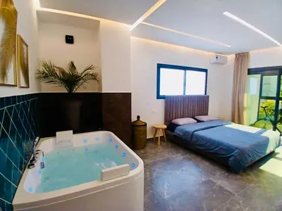 a bedroom with a tub and a bed in it at Résidence Fès Garden Piscine privé ou Jacuzzi in Oulad Tayeb