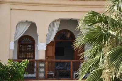 a house with a wooden door and a palm tree at Chambre SAPHIR - Riad Lotus Bleu in Fès