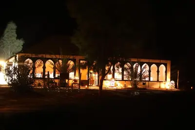 a building lit up at night with lights at Oasis Merzouga Retreat in Merzouga