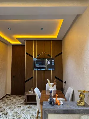 a dining room with a table and a television at Appartement confortable près du centre Meknes in Meknès