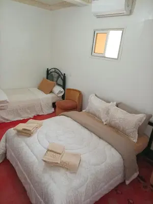 a bedroom with two beds and a window at skoura in Oulad el Guern