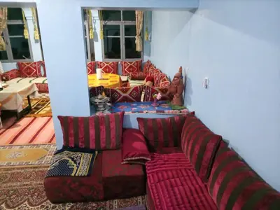 a living room with a couch with pillows at skoura in Oulad el Guern