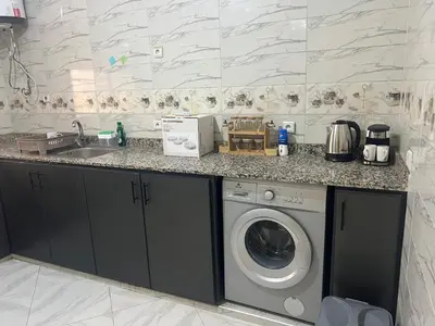 a kitchen with a washing machine and a sink at Luxe University Apartment 1 in Fès