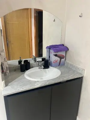 a bathroom counter with a sink and a mirror at Luxury University Apartment 3 in Fès