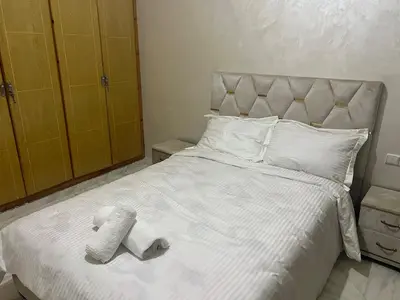 a bedroom with a white bed with two towels on it at Luxury University Apartment 3 in Fès
