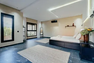a bedroom with a bed and two rugs at Romilli atlas in Sbiti
