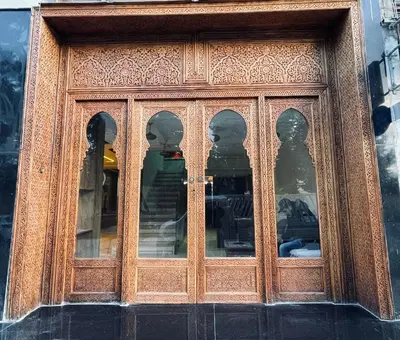 a wooden door with many windows on a building at Hôtel kairouan in Fès