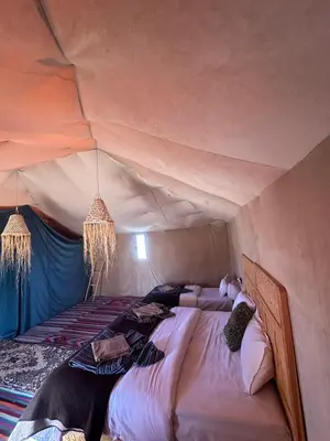 a bedroom with a bed in a tent at Royal Erg Chebbi Luxury Camp in Hassilabied