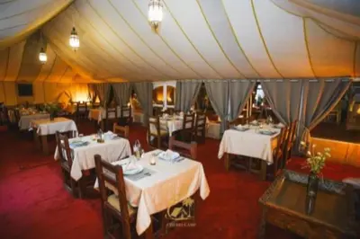 a dining room with tables and chairs in a tent at Global Desert Luxury Camp in Merzouga