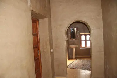 a hallway with a bathroom with a sink and a mirror at dorada apartamento in Merzouga