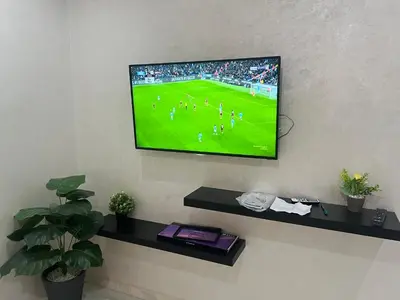 a tv on a wall with a soccer game on it at Université luxe appart2 in Fès