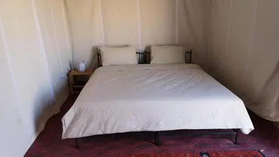 a bed with two pillows on it in a room at Desert Family Camp in El Gouera