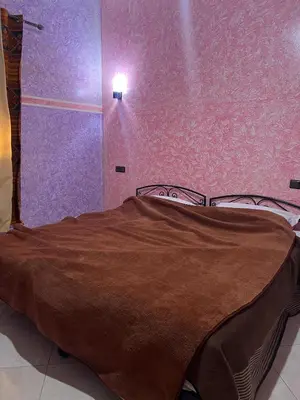 a bedroom with a bed with a brown blanket at Dream Merzouga Rooms in Merzouga