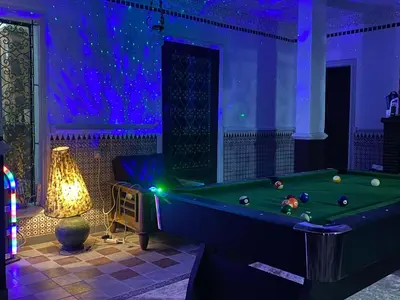 a room with a pool table and a lamp at Chambre dans un magnifique petit riad avec piscine in Aghmat
