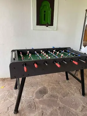 a ping pong table with a board on it at Chambre dans un magnifique petit riad avec piscine in Aghmat