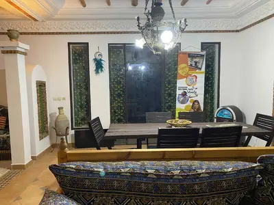 a dining room with a table and chairs at Chambre dans un magnifique petit riad avec piscine in Aghmat